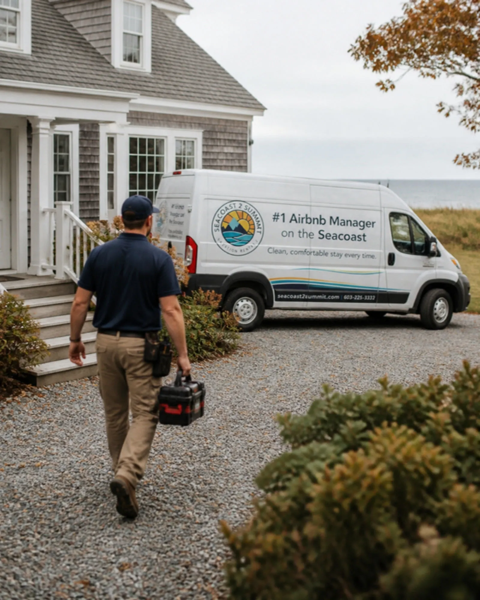 A Seacoast 2 Summit maintenance technician walks up to a shingled coastal home, with the company van parked in the driveway